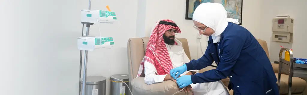 Patient receiving IV biologic infusion in a clinical setting in Riyadh